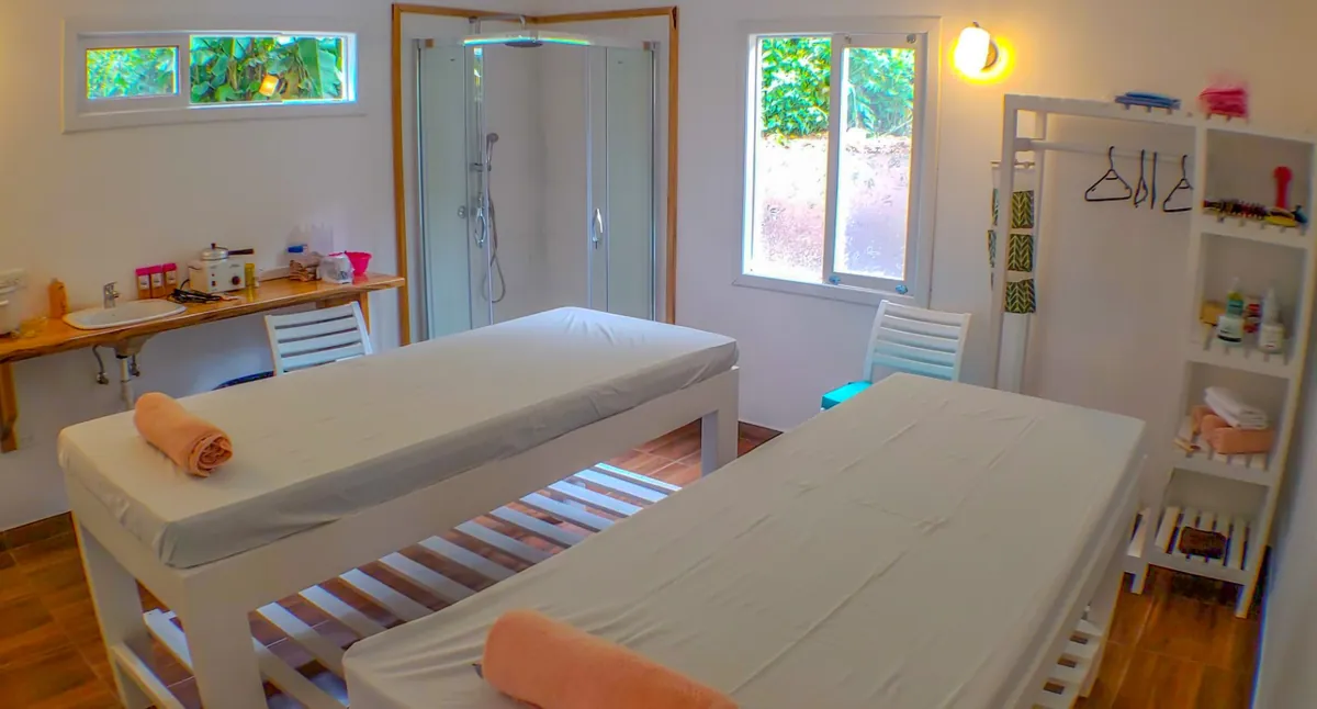 Couples room with two massage tables and a shower at Mandragora Spa, Mindo